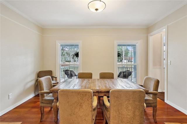 dining area with dark wood finished floors, crown molding, and plenty of natural light