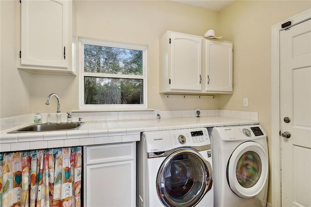 laundry room with cabinet space, washing machine and clothes dryer, and a sink