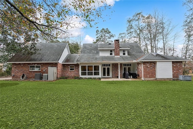 rear view of house featuring a patio, brick siding, central air condition unit, and a lawn