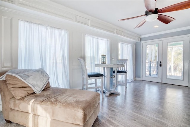 interior space with ornamental molding, hardwood / wood-style floors, ceiling fan, and french doors