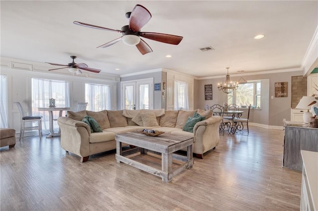 living room featuring ceiling fan with notable chandelier, ornamental molding, light hardwood / wood-style floors, and french doors