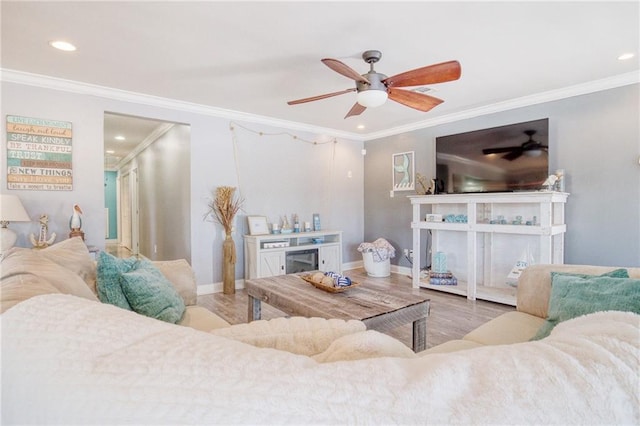 living room with crown molding, ceiling fan, and wood-type flooring