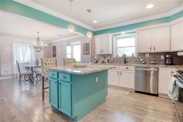 kitchen with appliances with stainless steel finishes, white cabinets, hanging light fixtures, a center island, and light stone countertops