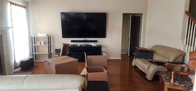 living room with a wealth of natural light and dark hardwood / wood-style flooring