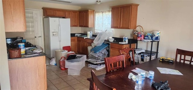 kitchen featuring light tile patterned floors and white refrigerator with ice dispenser