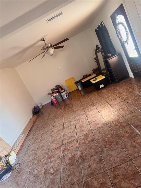 entryway with lofted ceiling, tile patterned flooring, and ceiling fan