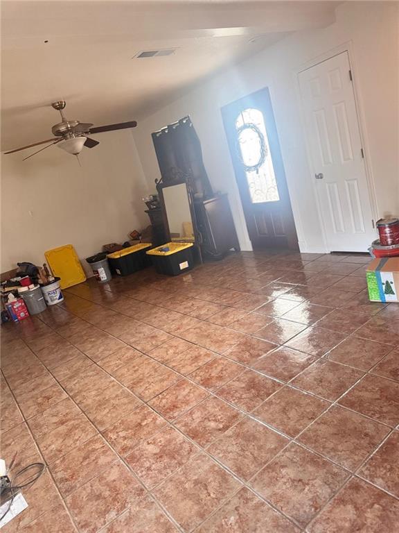 tiled foyer featuring ceiling fan