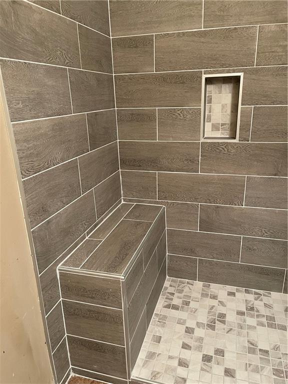 interior details with a tile shower