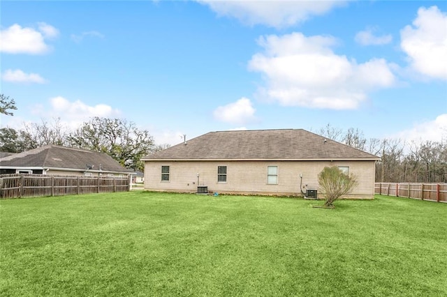 back of property with a lawn and central air condition unit