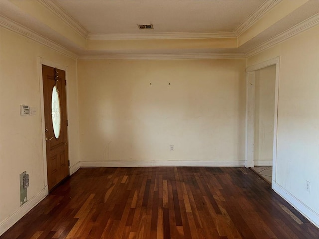 foyer entrance featuring dark wood-type flooring, ornamental molding, and a raised ceiling