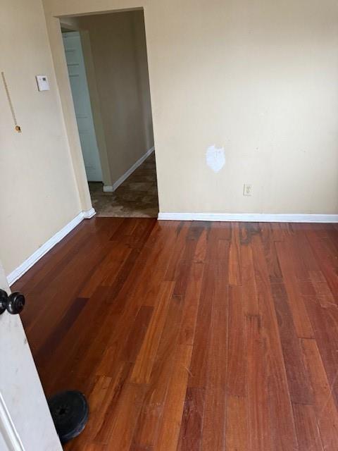 unfurnished room with dark hardwood / wood-style flooring