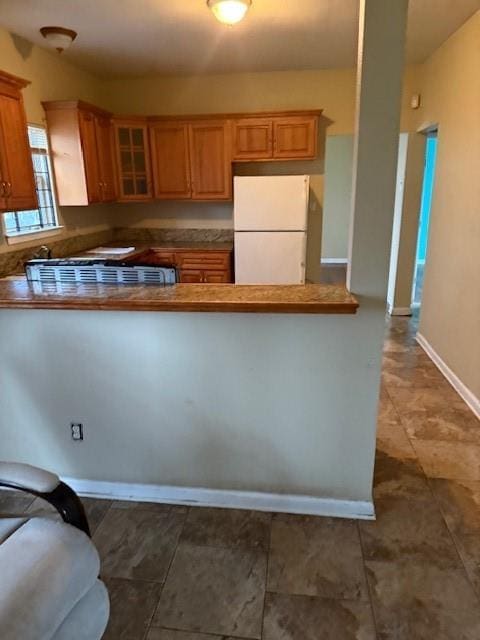 kitchen with white refrigerator and kitchen peninsula