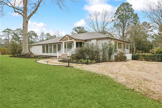 view of front facade with a sunroom and a front lawn