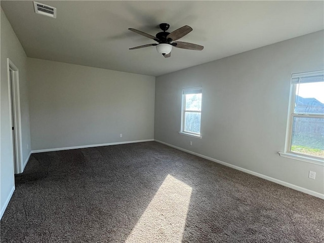 carpeted empty room featuring plenty of natural light and ceiling fan