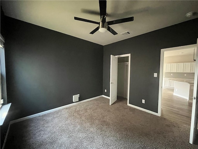 unfurnished bedroom featuring carpet, ceiling fan, and a closet