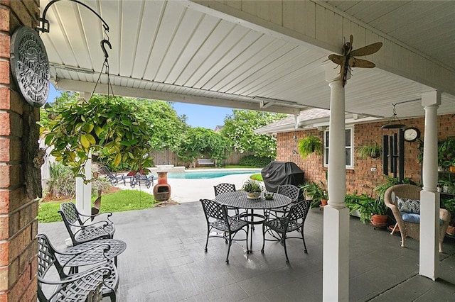 view of patio / terrace featuring ceiling fan and a fenced in pool