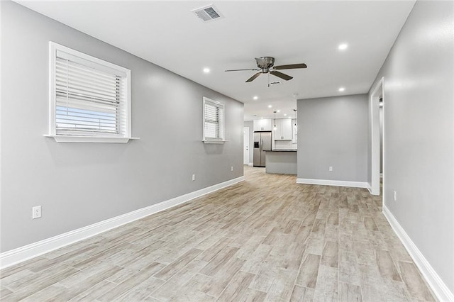 unfurnished living room featuring light wood-type flooring and ceiling fan