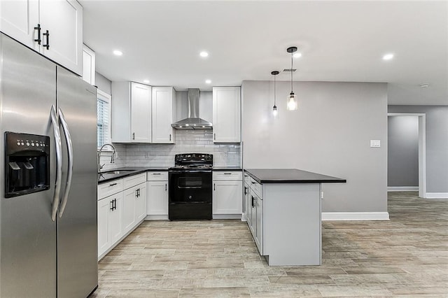 kitchen with wall chimney exhaust hood, white cabinetry, decorative light fixtures, black / electric stove, and stainless steel fridge