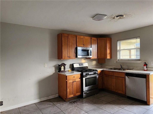 kitchen featuring sink, light tile patterned floors, and appliances with stainless steel finishes