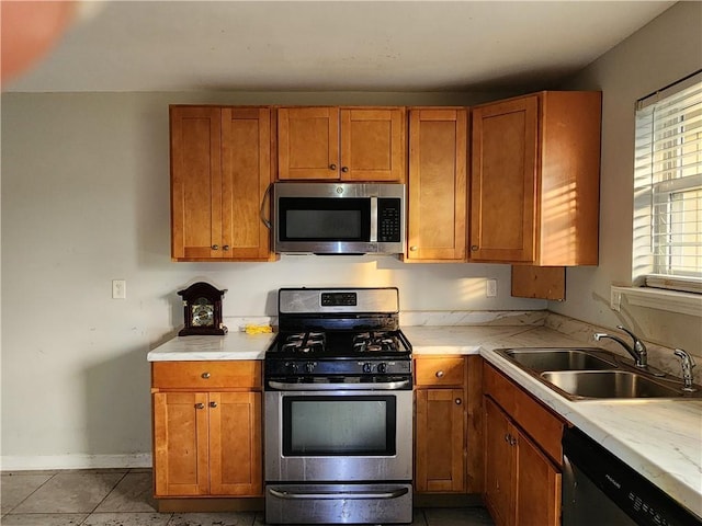 kitchen featuring stainless steel appliances, sink, and tile patterned floors