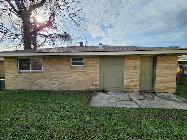 back of house featuring central AC, a lawn, and a patio