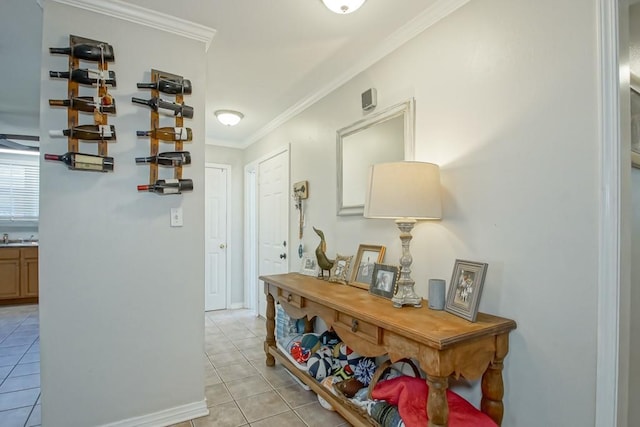 hallway featuring light tile patterned floors, a sink, and crown molding