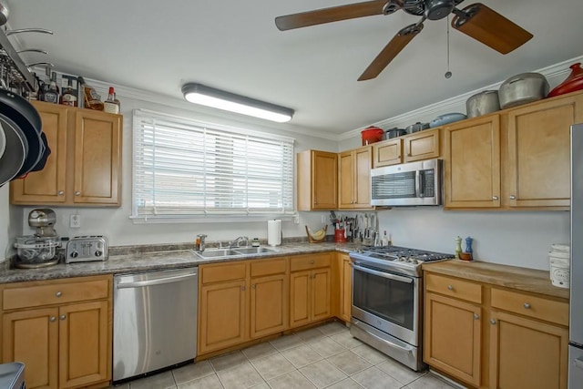 kitchen featuring light tile patterned floors, stainless steel appliances, a ceiling fan, ornamental molding, and a sink