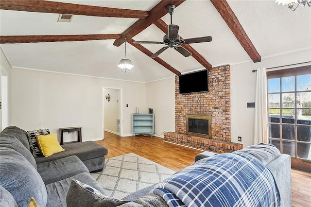 living room featuring hardwood / wood-style flooring, a fireplace, lofted ceiling with beams, and ceiling fan