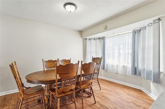 dining room featuring hardwood / wood-style flooring and a textured ceiling