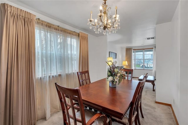 carpeted dining room featuring a notable chandelier