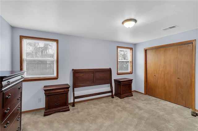 living area with light carpet and a closet