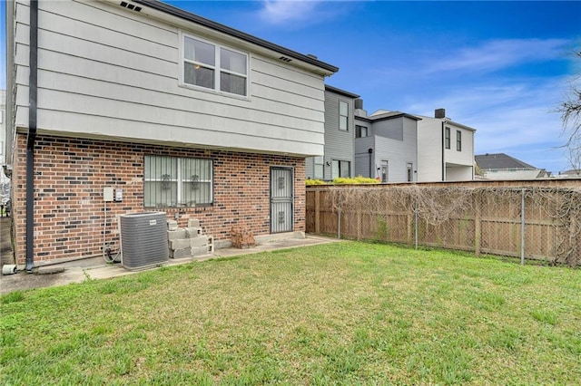 back of property featuring central AC and a yard