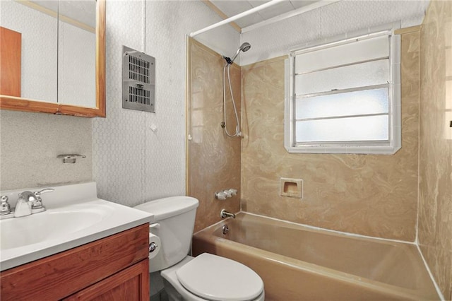 full bathroom featuring vanity, tiled shower / bath combo, and toilet