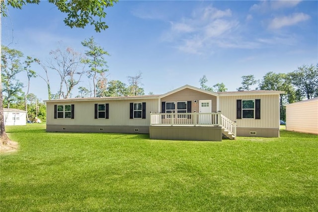 rear view of property featuring a yard and a deck