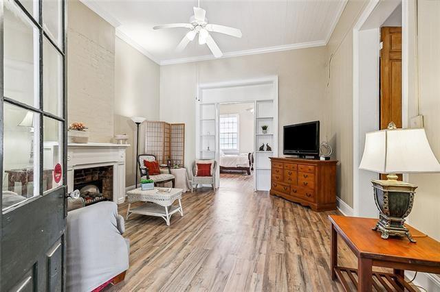 1224 Bourbon St Unit 1, New Orleans, LA 70116 - living room featuring ornamental molding, a ceiling fan, wood finished floors, and a fireplace