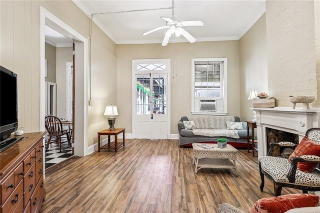 1224 Bourbon St Unit 1, New Orleans, LA 70116 - living room with a fireplace, ornamental molding, wood finished floors, ceiling fan, and cooling unit