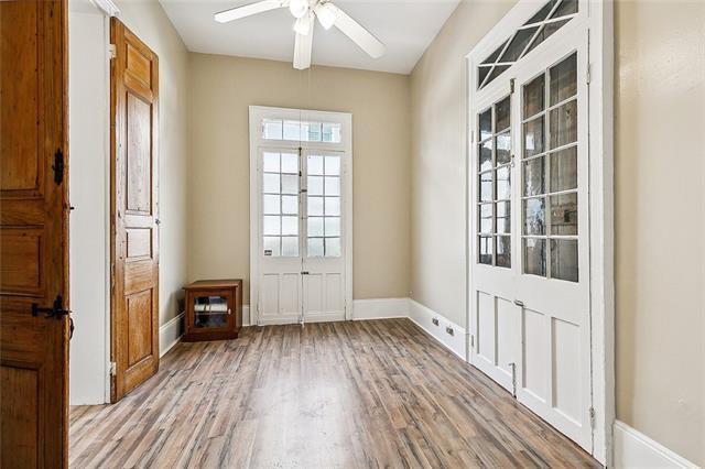 1224 Bourbon St Unit 1, New Orleans, LA 70116 - doorway with light wood-type flooring, ceiling fan, and baseboards