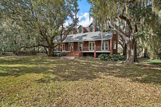 back of house with a yard and covered porch