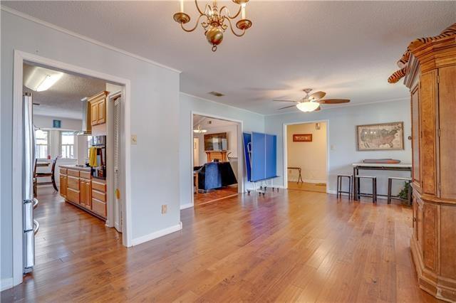 interior space featuring crown molding, ceiling fan with notable chandelier, and light hardwood / wood-style floors