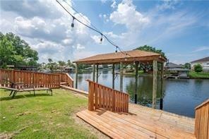 view of dock featuring a water view and a yard