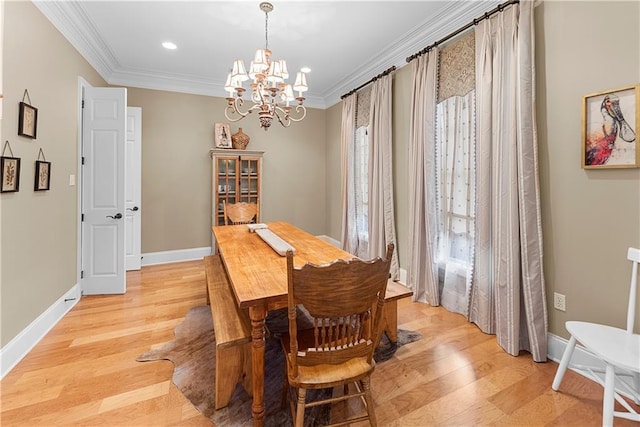 dining area with an inviting chandelier, ornamental molding, and light hardwood / wood-style floors