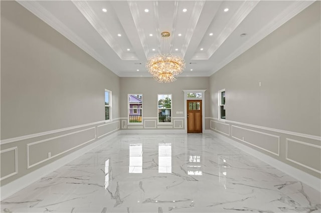 spare room featuring crown molding, plenty of natural light, an inviting chandelier, and a tray ceiling