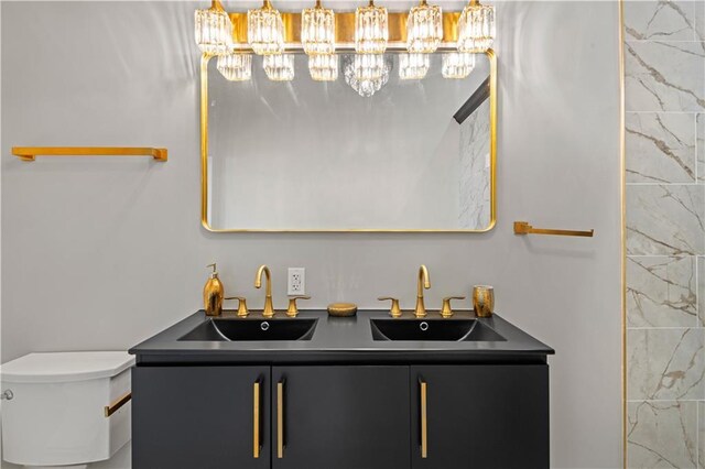 423 Diana St, New Orleans, LA 70114 - bathroom with double vanity, a chandelier, and toilet
