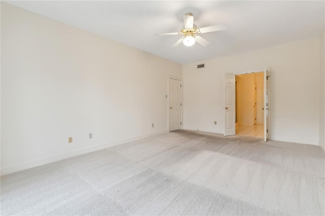 spare room featuring light colored carpet and ceiling fan