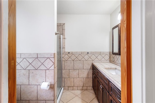 bathroom featuring walk in shower, tile patterned floors, vanity, and tile walls