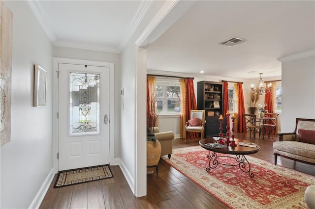 foyer entrance with dark hardwood / wood-style flooring, a notable chandelier, and ornamental molding