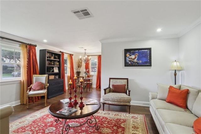 living room with ornamental molding, dark wood-type flooring, and a chandelier