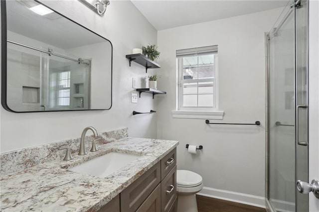 bathroom featuring a shower with door, vanity, hardwood / wood-style flooring, and toilet