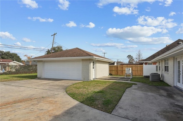 view of home's exterior featuring a garage, an outdoor structure, a lawn, and central air condition unit