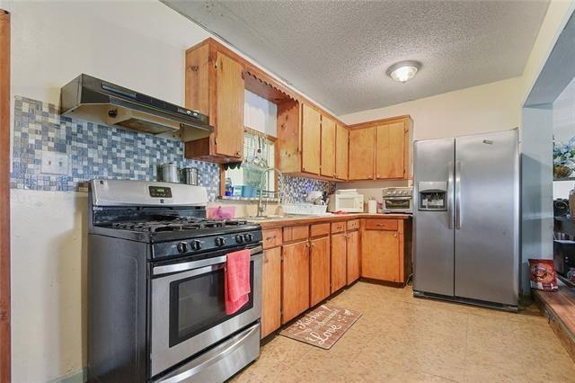 kitchen with stainless steel appliances, a textured ceiling, and decorative backsplash